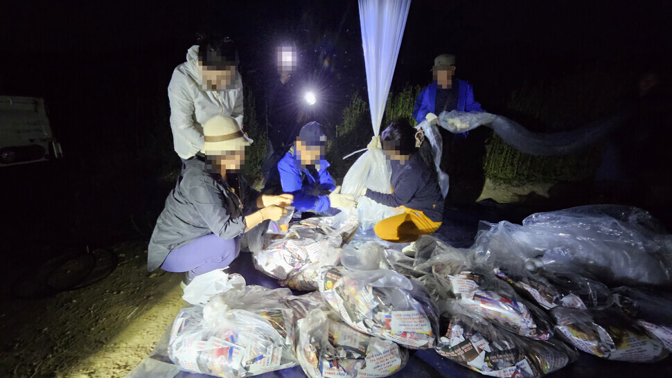 Members of a defector group prepare balloons filled with propaganda posters to be launched across the border into North Korea on the evening of June 7, 2024, from Ganghwa Island. The organization released a statement on June 8 saying that it had sent around 10 balloons filled with 200,000 leaflets criticizing Kim Jong-un northward. (Yonhap/courtesy of NKPLF)