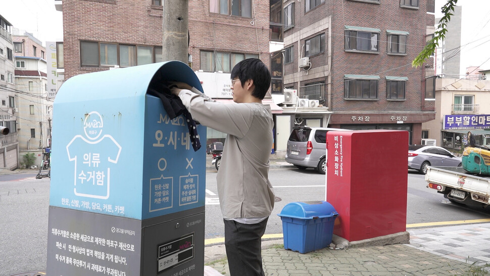 ④취재팀은 추적기를 단 헌 옷을 전국의 헌 옷 수거함에 넣었다. 사진은 서울 마포구의 한 헌 옷 수거함에 옷을 넣는 모습. 한겨레 조윤상 피디.