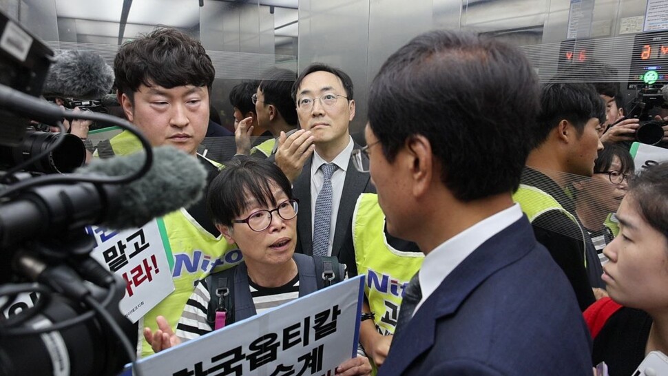 2025년 10월15일 금속노조 한국옵티칼하이테크지회 조합원들이 국회에서 이배원 니토옵티칼 대표(오른쪽 등진 이)를 해고 3년 만에 처음 만나 해고의 부당함에 대해 항변하고 있다. 사진 김주영 의원실 제공