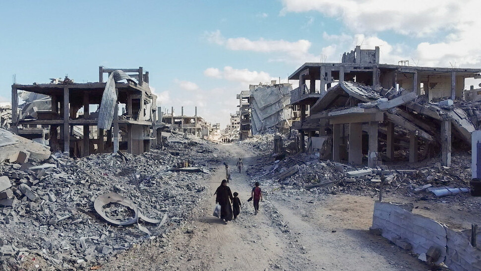 2025년 10월18일 팔레스타인 땅 가자지구 북부 가자시티에서 주민들이 폐허가 된 거리를 지나고 있다. REUTERS 연합뉴스