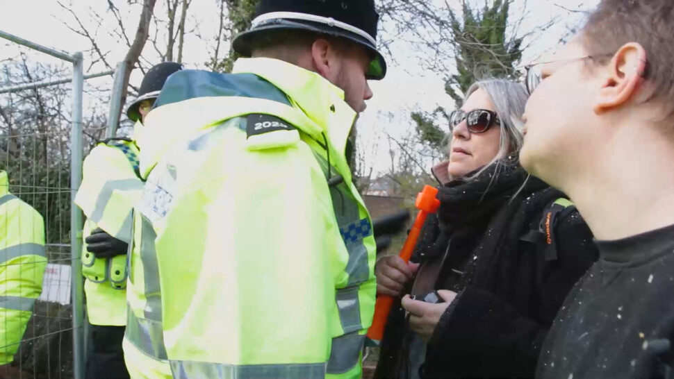 ‘더 펠링’의 한 장면. 장난감 트럼펫을 불며 항의하던 57살 여성이 ‘고의적으로 불쾌감을 유발했다’는 이유로 체포되고 있다.