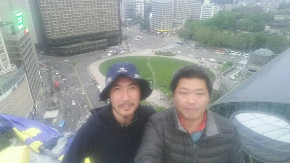 Irregular Kia Motors workers Choi Jeong-myeong (left) and Han Gyu-hyeop have a late lunch atop the National Human Rights Commission building in central Seoul