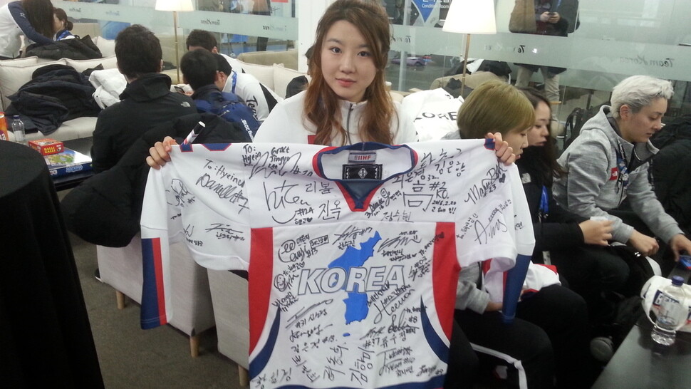 Korean’s women hockey team captain Ko Hye-in holds a jersey signed by all 35 members of the team.