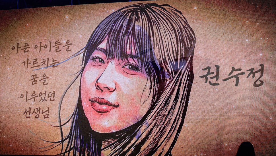 시민추모대회에서 이태원 참사 희생자 권수정씨의 이름이 불리는 동안 권씨의 캐리커처가 무대 화면을 가득 메우고 있다.