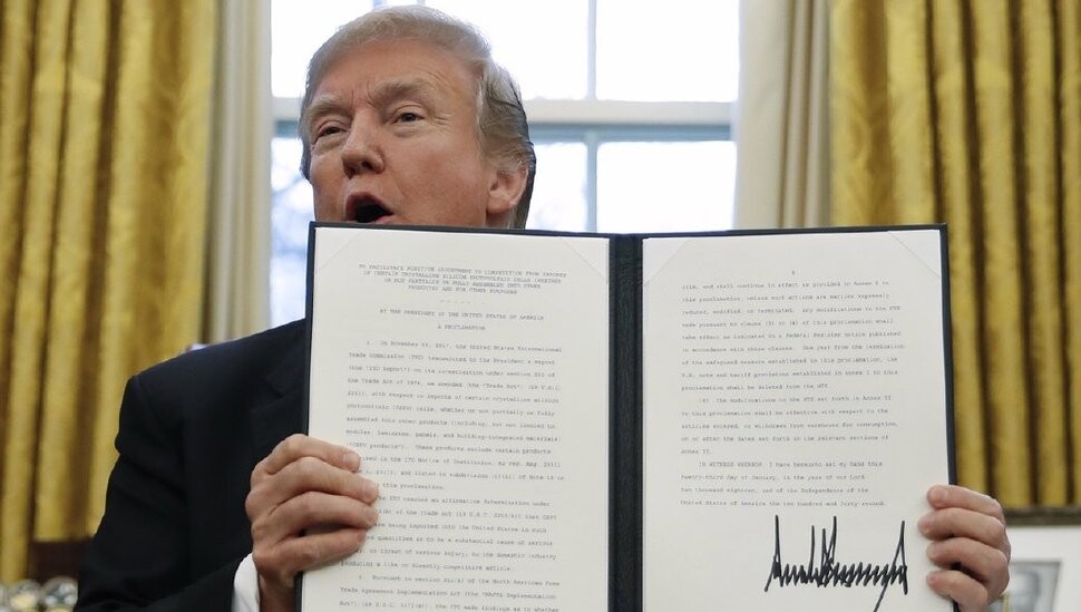 US President Donald Trump shows off the signed order imposing trade safeguards on South Korean washing machines and solar cells and modules under Section 201 of the Trade Act at the White House on Jan. 23. (Yonhap News)