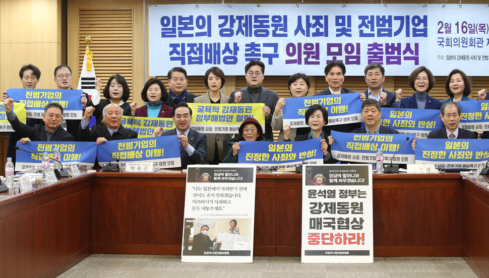 Yang Geum-deok and lawmakers pose with banners calling on Japan to offer a formal apology to victims of its forced labor conscription, the direct compensation of victims by offending Japanese corporations, and the withdrawal of the Korean government’s roundabout plan for compensation at the launch ceremony on Feb. 16 for a gathering of lawmakers aimed at working on the issue. (Shin So-young/The Hankyoreh)