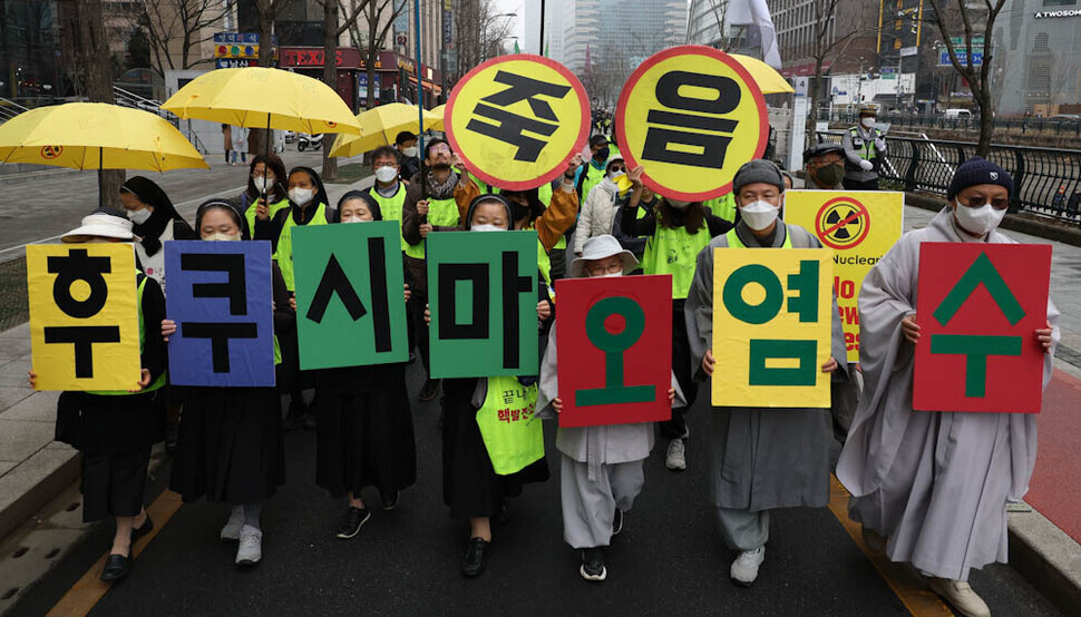 Participants in the March 8 rally hold up cards that read “Fukushima wastewater” during their march through central Seoul. (Kim Jung-hyo/The Hankyoreh)