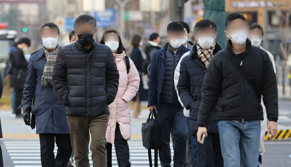 People make their way across a crosswalk in central Seoul’s Gwanghwamun on Thursday morning. (Yonhap News)