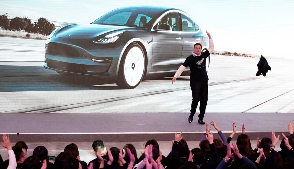 Tesla co-founder Elon Musk throws off his jacket while speaking at the launch of the Tesla Model 3 in Shanghai, China, in January 2020. (Reuters/Yonhap News)