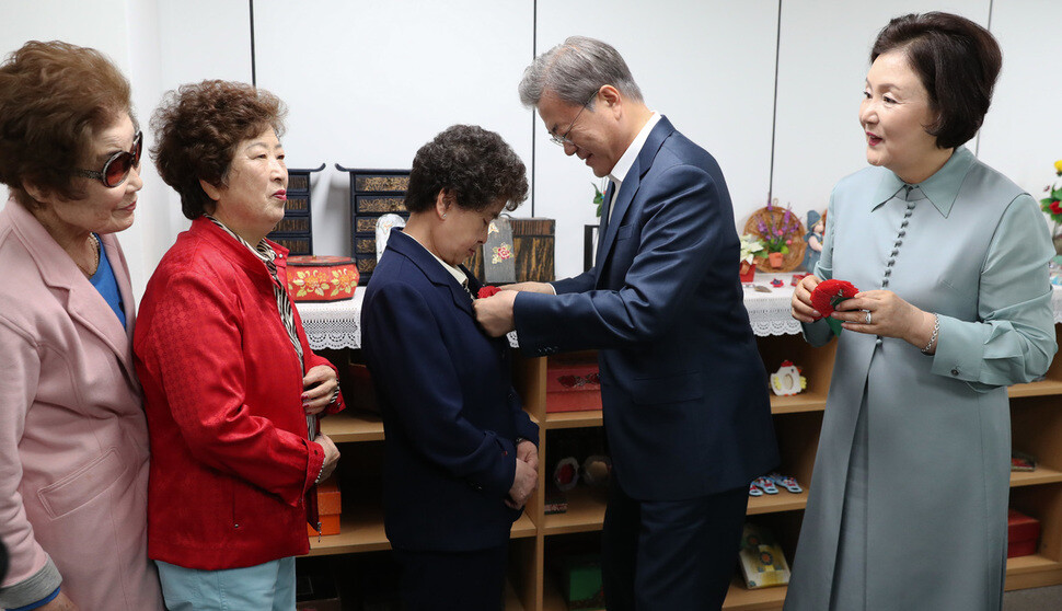 South Korean President Moon Jae-in and first lady Kim Jung-sook give out carnation pins to Alzheimer’s patients in Seoul’s Geumcheon District on May 7
