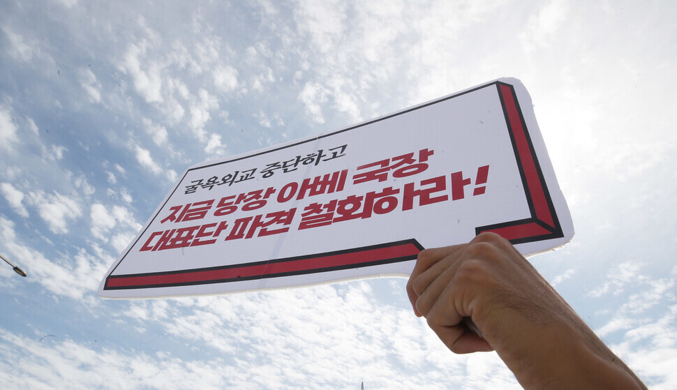 A member of Movement for One Korea holds up a sign on Sept. 27 calling on the government to walk back plans to send a delegation to the state funeral for Shinzo Abe, the former prime minister of Japan. (Shin So-young/The Hankyoreh)