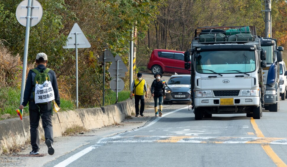 대형 화물차량이 많이 오가는 국도는 위험하다. 이종걸 활동가가 제법 뒤처진 참가자와 보조를 맞춰 걷는 미류 활동가를 기다리고 있다.