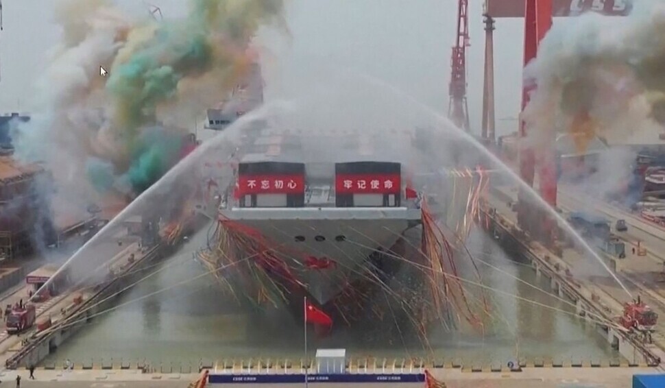 Water cannons spray China’s new aircraft carrier christened Fujian during its launching ceremony on June 17, 2022, as shown in this footage from China’s CCTV. (AP/Yonhap News)