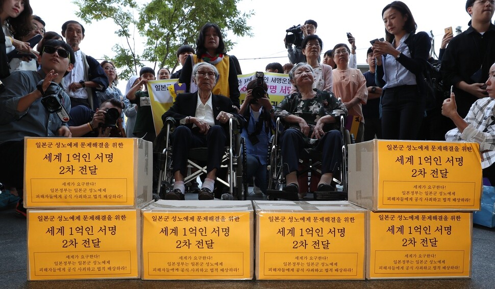Former Japanese comfort women Kim Bok-dong (L) and Gil Won-ok take part in a demonstration outside the former Japanese embassy building in Seoul’s Junghak neighborhood on Sept. 13.  Next to them are boxes containing the signatures of people worldwide who are supporting the “100 million global citizen campaign” to demand apology from the Japanese government and restitution for the women.