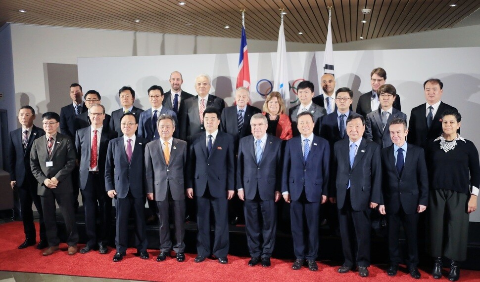 Members of North and South Korean delegations take a pose for a group photo with officials from the International Olympic Committee in Lausanne