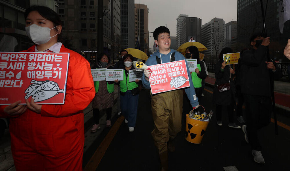 Members of environmental, civic, social, and religious groups march through Gwanghwamun in central Seoul on March 8 as part of a “nuclear phase-out day of action” event. (Kim Jung-hyo/The Hankyoreh)