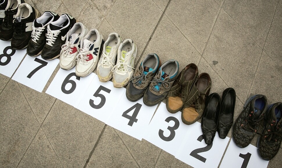 지난 1월 쌍용자동차 신차 티볼리를 출시하는 동대문디자인플라자(DDP) 행사장 입구에서 2009년 정리해고 사태 이후 숨진 동료 26명을 상징하는 신발 26켤레를 늘어놓는 행사가 열렸다. 박승화 기자