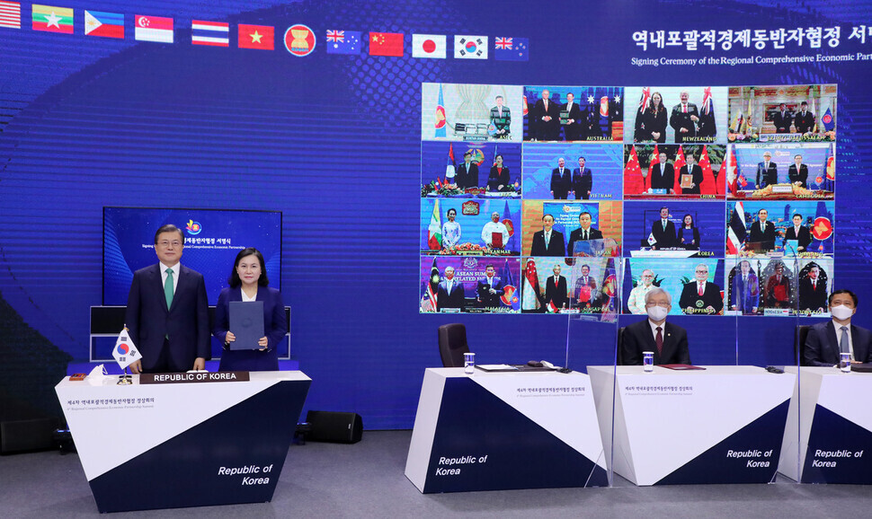 South Korean President Moon Jae-in and Trade Minister Yoo Myung-hee take part in the signing ceremony for the Regional Comprehensive Economic Partnership (RCEP) held via teleconference on Nov. 15. (Yonhap News)