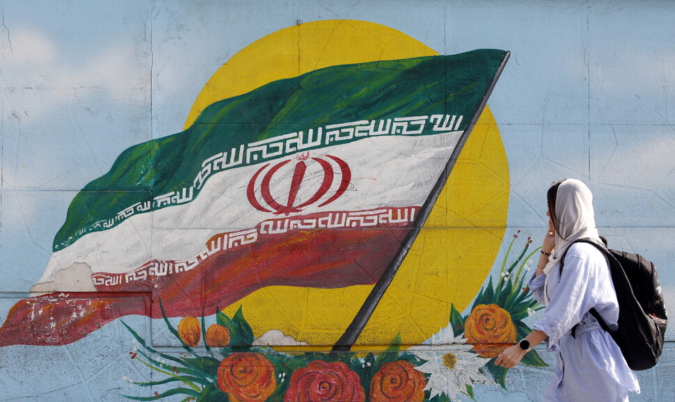 11월9일(현지시각) 이란 수도 테헤란에서 한 여성이 이란 국기가 그려진 벽을 지나가고 있다. 테헤란/EPA 연합뉴스