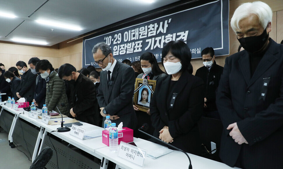 Family members of those who perished in the tragic Itaewon crowd crush last month stand and bow their heads in a moment of silence ahead of beginning their press conference held at the Miinbyun offices in Seoul’s Seocho District on Nov. 22. (pool photo)