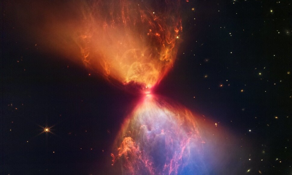 450광년 거리의 황소자리에 원시별 L1527. 모래시계의 목부분 검은색 띠 안에 가려져 있다. 나사 제공