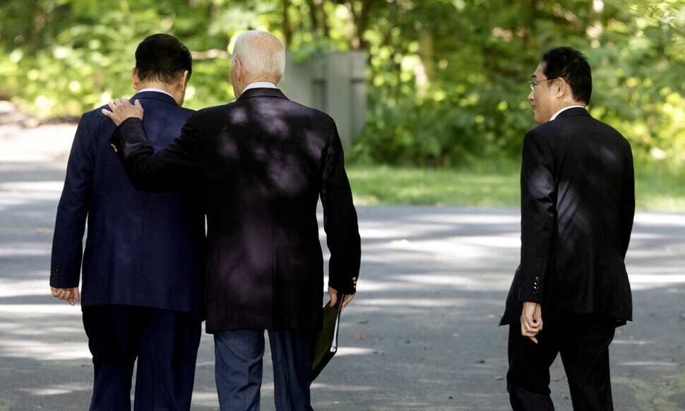 US President Joe Biden walks with his hand on the shoulder of South Korean President Yoon Suk-yeol as Japanese Prime Minister Fumio Kishida walks beside them following their post-summit joint press conference at Camp David in Maryland on Aug. 18. (EPA/Yonhap)