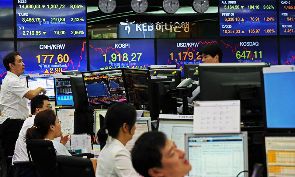 Foreign exchange dealers at KEB Hana Bank’s trading room in Seoul watch their monitors as they place orders
