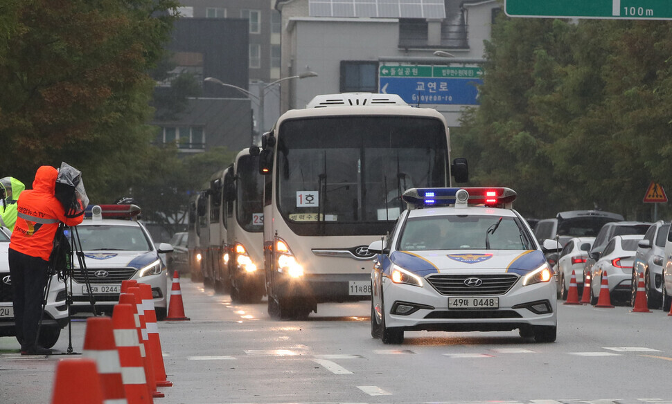 A police vehicle escorts buses transporting the Afghan nationals who recently arrived in South Korea on Friday as they enter the National Human Resources Development Institute in Jincheon, North Chungcheong Province. (Park Jong-shik/The Hankyoreh)