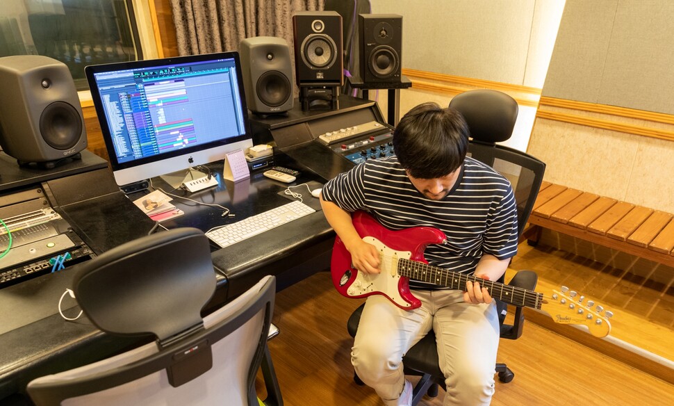 선우(가명)씨가 2022년 7월4일 서울 용산구 자신의 작업실에서 기타를 치고 있다.