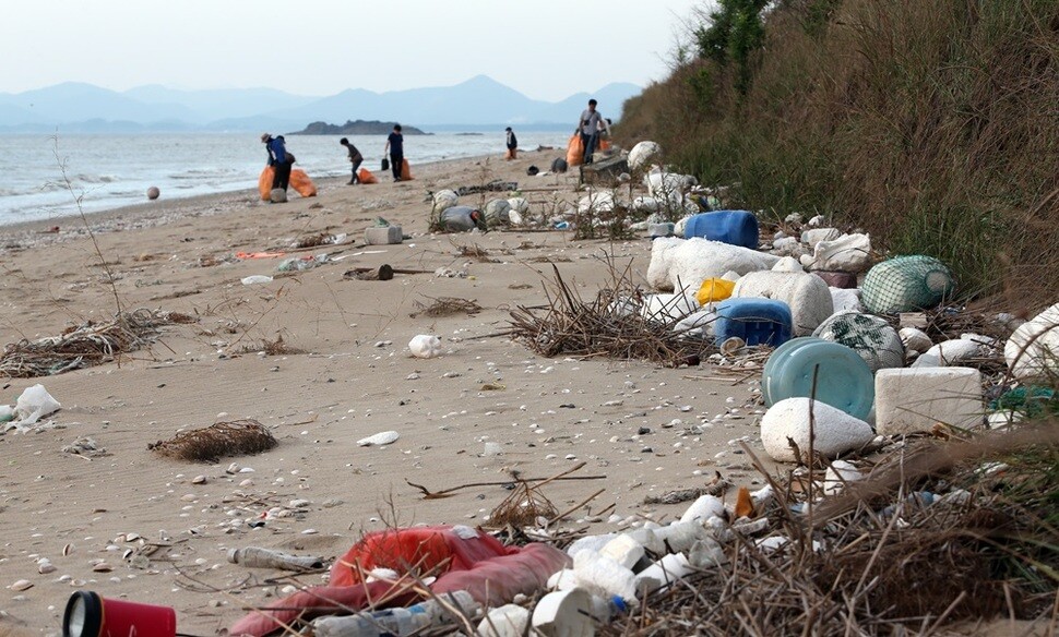 ‘섬 갯벌 클린 봉사단’이 파도에 떠내려온 쓰레기로 가득 덮인 유부도 해안을 치우고 있다.