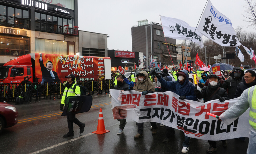 전국집중촛불 참가자들이 이태원 도로를 행진하는 동안, 신자유연대 회원들이 대형트럭(왼쪽)과 확성기를 동원해 소음을 내고 있다.