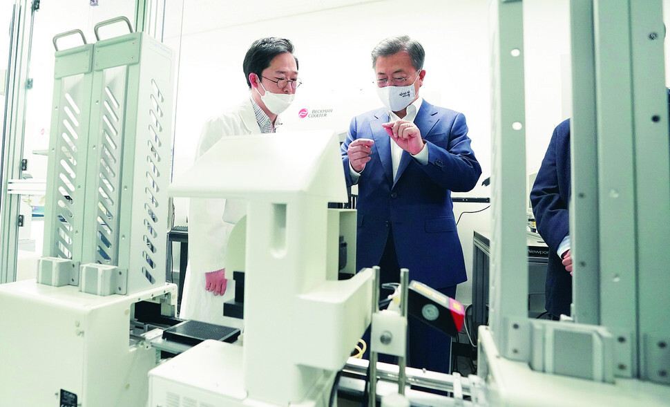 Lee Hong-geun, senior research fellow at the Institut Pasteur Korea in Seongnam, Gyeonggi Province, explains the processing of certain compounds to South Korean President Moon Jae-in on Apr. 9. (Blue House photo pool)