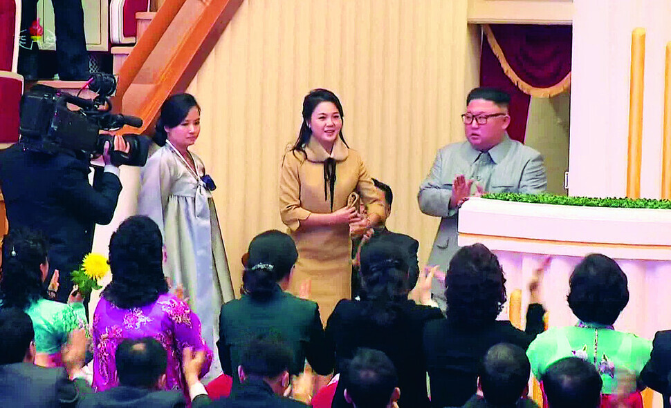 North Korean leader Kim Jong-un appears with first lady Ri Sol-ju at a holiday event held a Samjiyon Orchestra Theatre in Pyongyang on Jan. 25, 2020. On their left is Hyon Song-wol, the leader of the Samjiyon Orchestra at the time. (Still from KCTV/Yonhap)