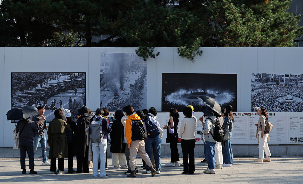 광주 동구 금남로 옛 전남도청 앞 광장에서 참석자들이 공사 현장 가림막에 걸려 있는 당시 사진을 보며 설명을 듣고 있다.