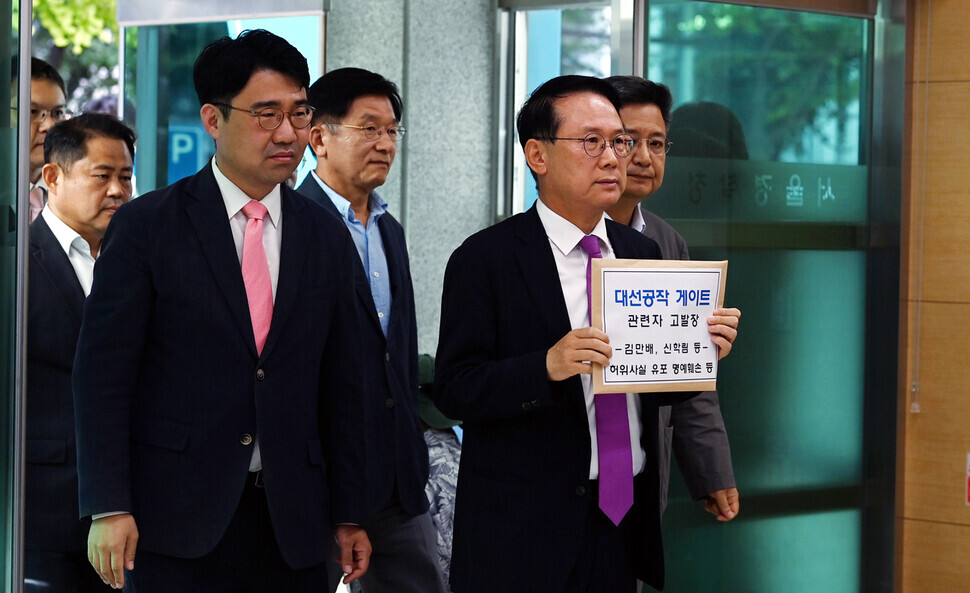 Yoon Do-hyun, the chair of the People Power Party’s special committee on media policy, and Kim Jang-kyom, the chair of the ruling party’s special committee on “preventing fake news and rumors,” are joined by other lawmakers as they file a complaint at the National Police Agency against Kim Man-bae, Shin Hak-lim, and journalists who reported on their allegedly faked interview. (Yonhap)