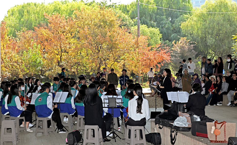 서울 영원중학교 ‘청소년적십자(RCY) 동감오케스트라’가 서울교 아래 샛강 숲속 콘서트홀에서 연주하고 있다. 이례적인 폭염으로 곳곳에 ‘지각 단풍’이 발생했다.