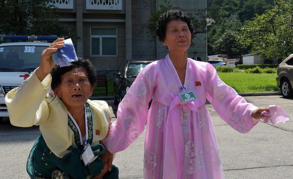 North Koreans wave goodbye to their family members as they prepare to head back to South Korea. (photo pool)