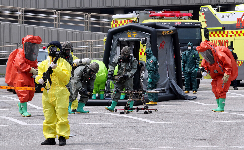 CBRN officers for the Seoul Metropolitan Police Agency SWAT team examine drones used in a chemical attack scenario during a joint drill held in Seoul on Tuesday to prepare for drone attacks. (Kim Gyoung-ho /The Hankyoreh)