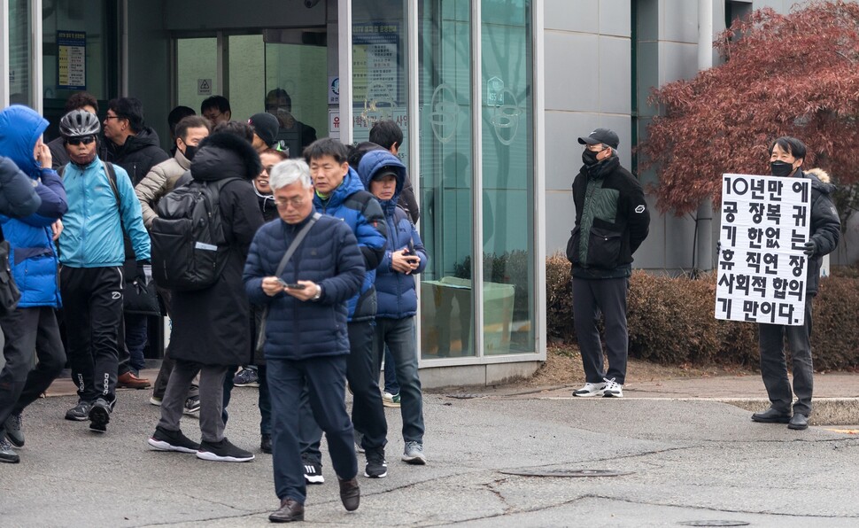 12월30일 오후 경기도 평택 쌍용자동차 정문 앞에서 복직 예정자 정재영(가명)씨가 복직 무기한 연장 결정을 비판하는 손팻말을 들고 서 있다.