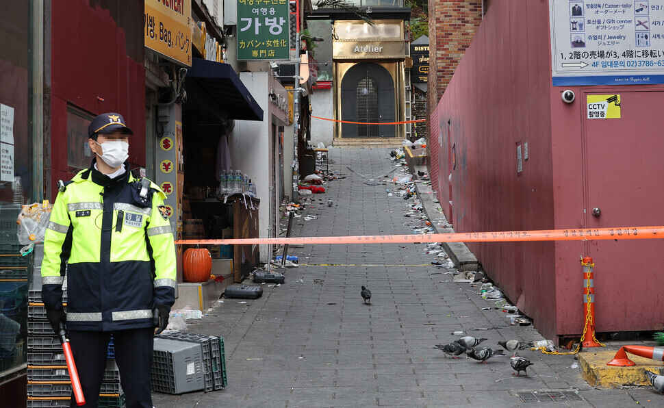 A police officer stands guard on Nov. 3 at the entrance to the alleyway in Itaewon where the deadly crowd crush took place on Oct. 29. (Yonhap)