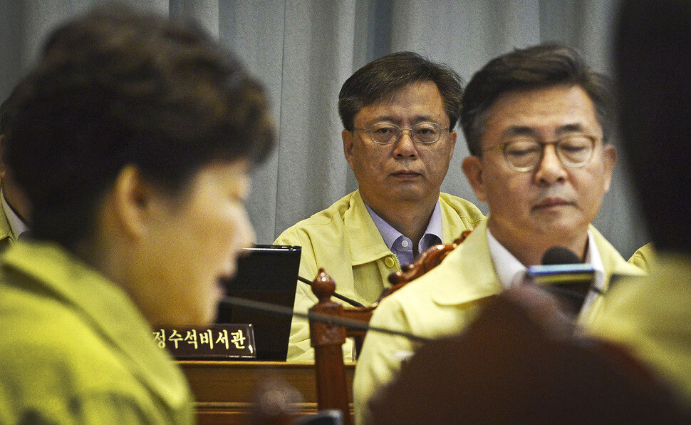 Senior Secretary to the President for Civil Affairs Woo Byung-woo listens to President Park Geun-hye’s address at a Cabinet Meeting at the Blue House on Aug. 22. (Blue House photo pool)