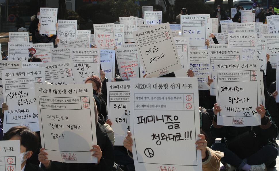 2022 페미니스트 주권자행동 회원들이 2022년 2월12일 오후 서울 종로 보신각 앞에서 열린 집회에서 대선 후보들에게 바라는 점을 적은 손팻발을 들고 있다. 한겨레 박종식 기자