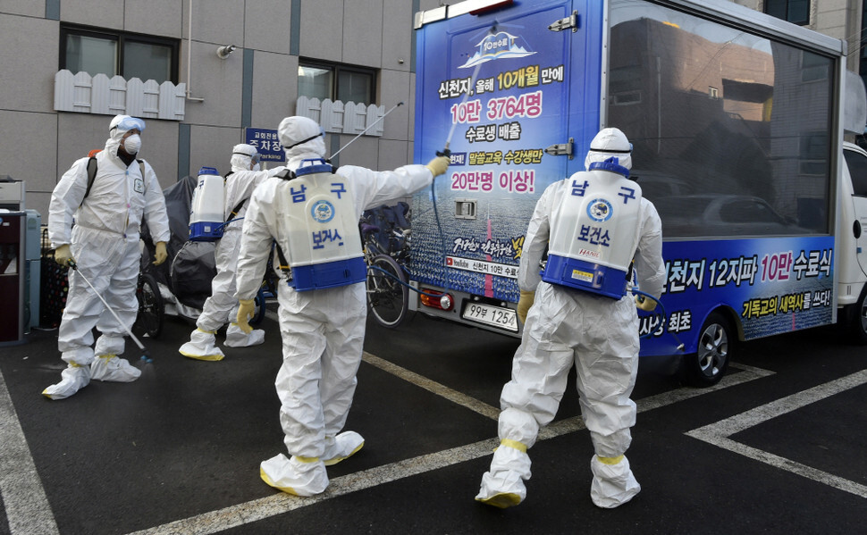 Workers sanitize the vicinity of the Daegu branch of the Shincheonji religious movement, where the novel coronavirus has infected multiple persons, on Feb. 19. (Yonhap News)