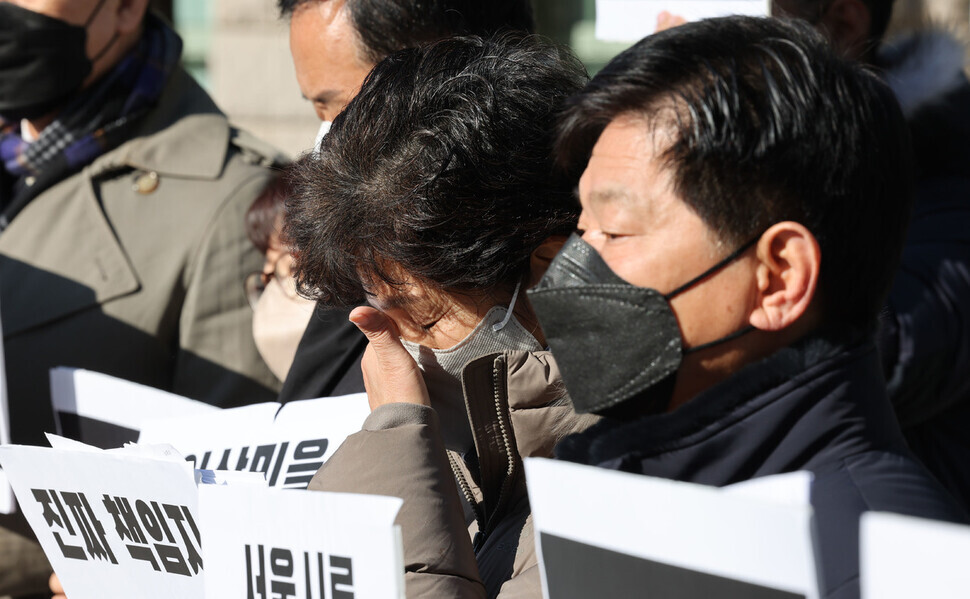 A family member of a victim of the crowd crush in Itaewon on Oct. 29 wipes away tears during a press conference outside of Seoul City Hall jointly organized by Minbyun-Lawyers for a Democratic Society and the People’s Solidarity for Participatory Democracy calling for an investigation into the Seoul metropolitan government for its lack of preparation for such a disaster. (Yonhap)