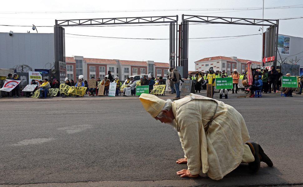 Police move participants in a mass at the entrance to the construction site of a naval base in Gangjeong Village