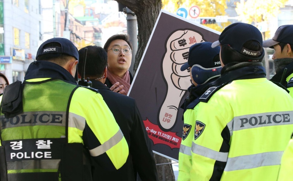 Police prevent People’s Solidarity for Participatory Democracy citizen engagement team secretary Kim Seung-hwan from accessing the fountain plaza in front of the Blue House to hold a one-person demonstration with signs reading “Step down