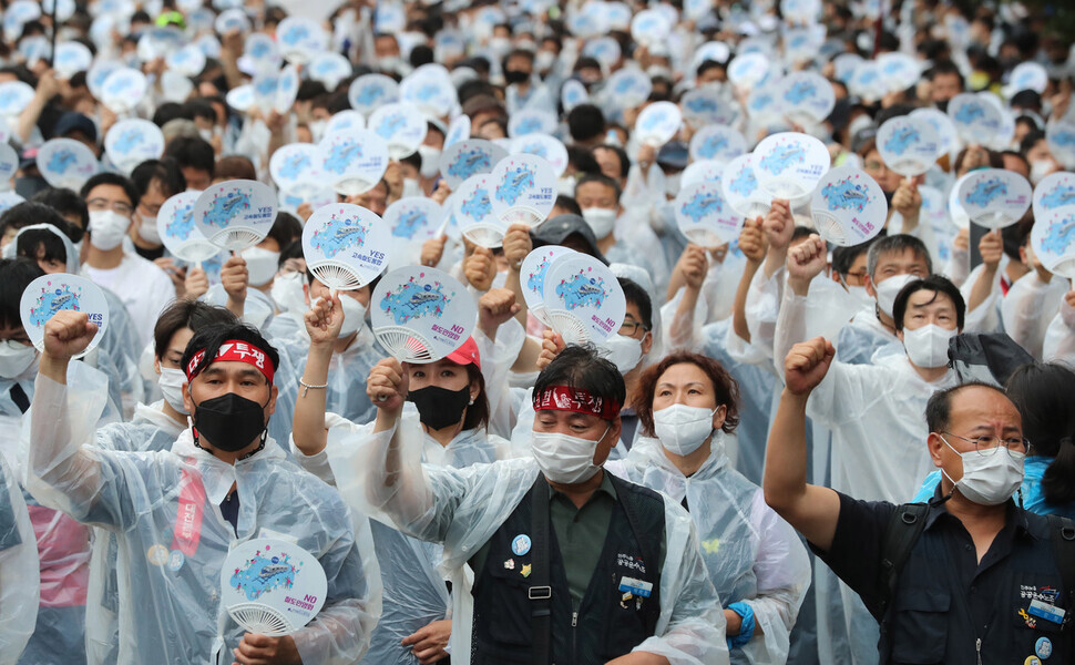Members of the Korean Railway Workers’ Union hold up fans and chant during a rally on June 28, Railway Day, outside of Seoul Station. (Shin So-young/The Hankyoreh)