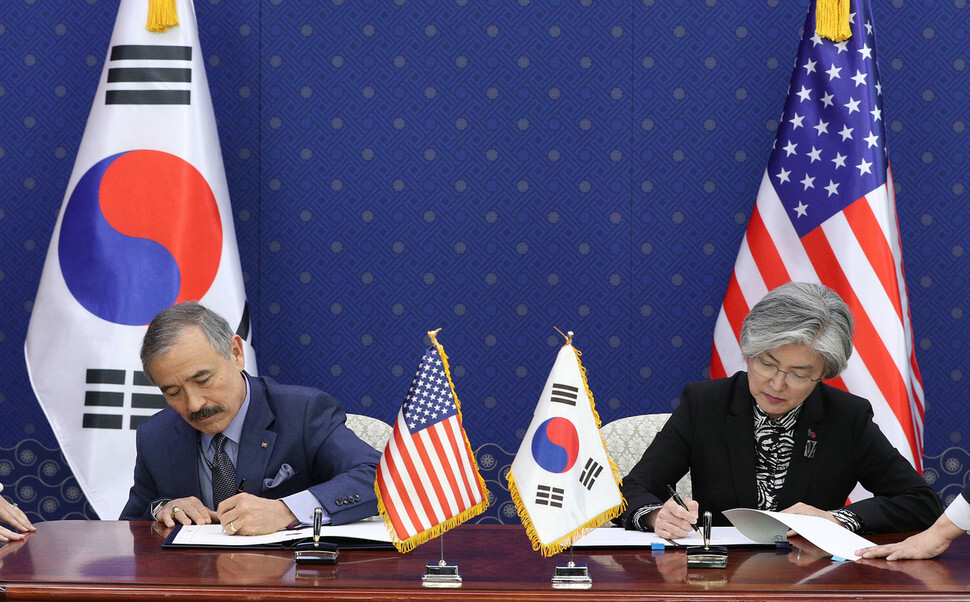 South Korean Foreign Minister Kang Kyung-hwa and US Ambassador to South Korea Harry Harris sign the South Korea-US special measures agreement (SMA) for defense cost-sharing at the South Korean Ministry of Foreign Affairs in Seoul on Mar. 8, 2018. (Hankyoreh archives)