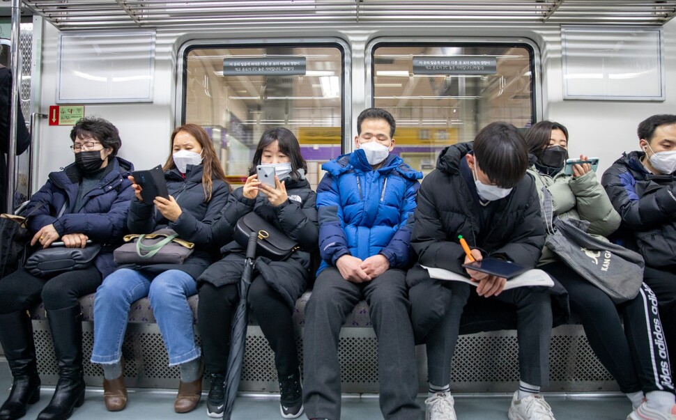 지하철 승객들이 빠짐없이 마스크를 쓰고 있다.