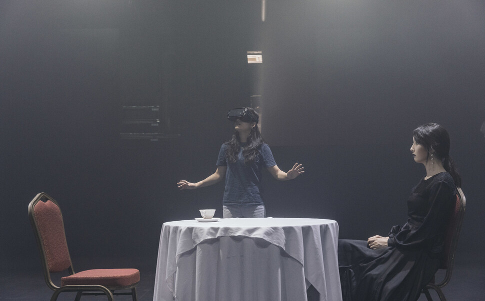 국립극단 &lt;코오피와 최면약&gt; 공연 중 텅빈 극장에서 관객이 홀로 브이아르(VR) 장비를 쓰고 공연을 관람하고 있다. 국립극단 제공